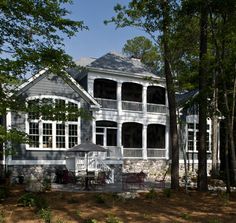 a large white house surrounded by trees and bushes