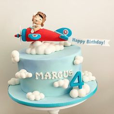 a blue birthday cake with a boy on top