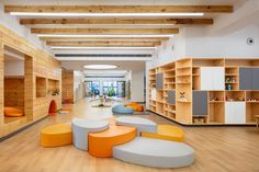 an open room with lots of furniture and wooden shelves on the walls, along with bookshelves