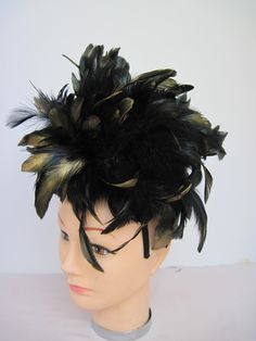 "* This fascinator features coal black 6-7\" feathers all tipped in gold. Perfect for fall and winter and with the spider fantastic for Halloween or a costume party. If desired, you can remove the spider. * A generous supply of feathers create a feminine look and allows any slight breeze to create a flutter adding motion and sophistication to the design. * On a black satin covered acrylic headband the design is secure, evenly balanced and on trend with the gold tipping. Try it on front to back a Black Ostrich Feather Headpiece, Black Ostrich Feather Trim Headpiece, Black Feathered Headpiece For Costume, Black Feathered Headpiece For Evening, Black Feather Trim Headpiece For Evening, Black Headpiece With Feather Trim For Evening, Black Mini Hats With Feather Trim For Party, Black Mini Hat With Feather Trim For Party, Black Feathered Headband Fascinator