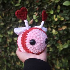 a hand holding a small crocheted animal with antlers on it's head