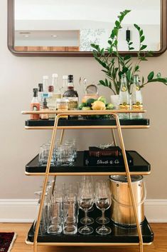 a bar cart with drinks and glasses on it