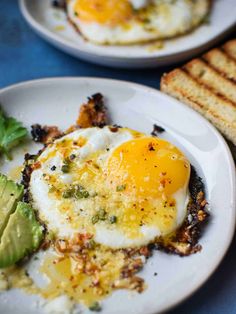 an egg and avocado on a plate with toast