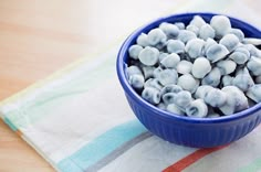 a blue bowl filled with marshmallows sitting on top of a striped towel