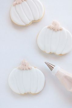 three decorated cookies with icing and a pen