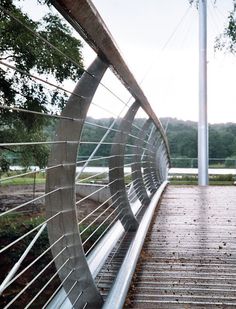 a person walking across a bridge with a skateboard on it's handrail