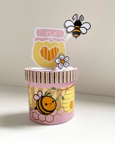 two honey jars with stickers on them sitting next to each other in front of a white wall