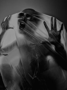 a black and white photo of a person wrapped in plastic