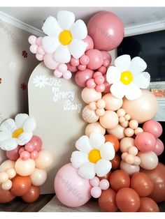 the balloon arch is decorated with daisies and balloons in pink, white, and peach colors