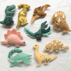 small felt dinosaurs are arranged on a table