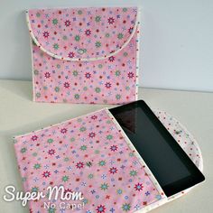 an ipad case with flowers on it and a tablet in the front, sitting on a table