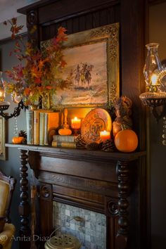 a mantle with candles and pumpkins on it