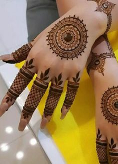 two hands with henna tattoos on them