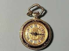 an antique gold pocket watch with roman numerals