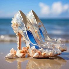 a pair of high heeled shoes sitting on top of a beach