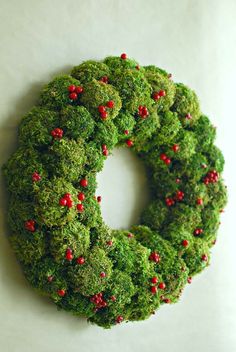 a green wreath with red berries on it