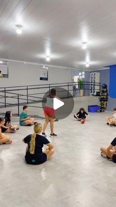 a group of people sitting on the floor in a gym