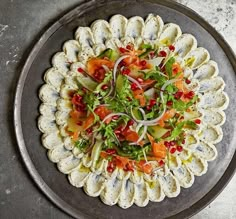 a platter filled with food on top of a metal table next to utensils