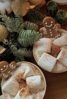 two cups filled with hot chocolate and marshmallows on top of a wooden table