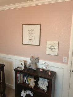 a baby's room with pink walls and stuffed animals on the bookcases