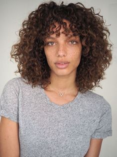 a woman with frizzy hair is posing for the camera