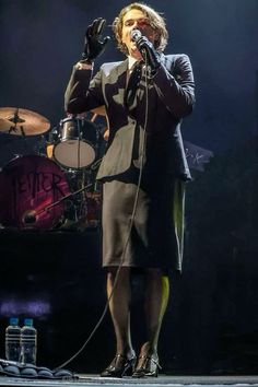 a woman standing on top of a stage holding a microphone