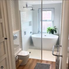 a bathroom with a toilet, sink and bathtub next to a window in it