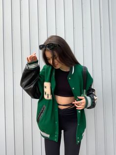 a woman in black top and green jacket