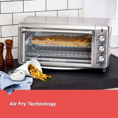 a toaster oven with food cooking in it and the words air fry technology above it