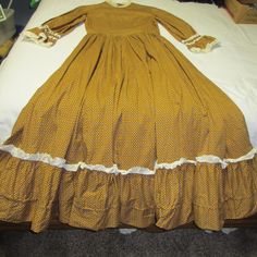 Great Handmade Cotton Pioneer Prairie Dress with Bonnet & Purse, Cotton Fabric & Lots of it, the Dress is very Full A Petticoat Skirt would look great under the dress. Back as Zipper From top neck to bottom zipper 19",  Flat Measurements: Armpit to Armpit 18", Length from Back Center of Neck to Bottom Hem 55" , Sleeve Length Under Armpit to End of Sleeve 15", Waist 14",  Bottom Width of Dress 8' Very Full   Bonnet 11" Wide Flat Bill On Bonnet 5"    Great for Halloween or Clothing Wore During Western Frontier Times Please Check your Measurements as I do Not do Returns! Thanks  Very Good Condition (968) Traditional Formal Dress For Fall, Fitted Cotton Vintage Costume Dress, Fitted Cotton Vintage Dress For Costume, Vintage Full Skirt Dress With Ruffles, Fitted Cotton Costume Dress, Fitted Petticoat For Dressmaking, Traditional Brown Formal Dress, Retro Long Sleeve Costume Dress, Prairie Daywear Dresses With Ruffles