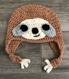 a crocheted hat with a slotty face on it's front and sides