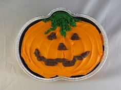 a pumpkin shaped cake sitting on top of a white table