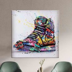 a painting of a pair of sneakers with colorful paint splatters on it's side