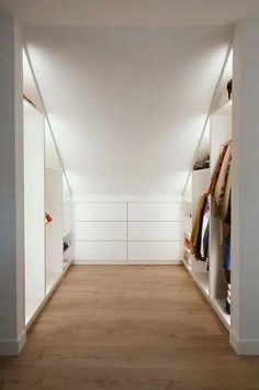 an empty closet with white walls and wooden floors