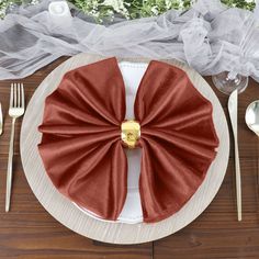 a table setting with silverware, napkins and red bow - tie napkins