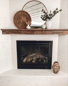 a fire place with a mirror above it