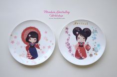 two plates decorated with geisha dolls on them