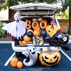 the back of a car with balloons and decorations in the trunk, including ghostes