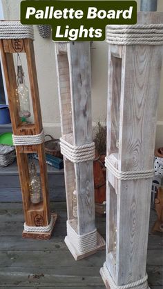 three tall white wooden vases sitting next to each other on a porch with rope wrapped around them