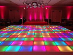 the dance floor is lit up with colorful lights