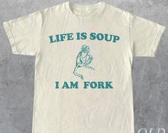 Life Is Soup I Am Fork Frog Graphic T Shirt, Unisex Funny Retro Shirt, Funny Frog Meme Tee, Vintage Style Relaxed Cotton Shirt, Frog Lovers. Elevate your style with our premium cotton shirt. Crafted for comfort and designed for versatility, this shirt is perfect for any occasion. Whether you're dressing up for a special event or keeping it casual, our shirt's quality and timeless design will make you stand out. Choose excellence, choose our shirt. #vintage style #frog #funny retro #Shirt #Snorid Life Is Soup I Am Fork, Frog Graphic, Frog Meme, Silly Shirt, Funny Frogs, Funny Tee Shirts, Weird Shirts, Cool Graphic Tees, Funny T Shirts