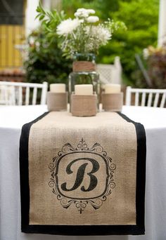 a table topped with a white table cloth covered in black and white monogrammed napkins