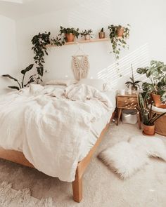 a bed with white linens and plants on the headboard, along with a rug