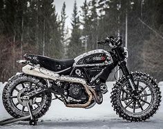 a black and white dirt bike parked in the snow