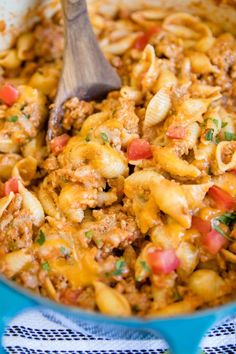 a skillet filled with macaroni and cheese on top of a blue towel