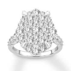 a white gold ring with two rows of diamonds on the band and an oval shaped center