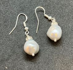 This gorgeous pair of drop earrings have been handmade using vintage fresh water pearl baroque pearls with Czech spacers onto new silver wires. The width of the pearl approx is 1.3 cm and the drop from the wire is 2.5 cm .  Come unworn in a gift box, a great gift or a treat for yourself. Silver Baroque Pearl Drop Earrings, Silver Baroque Pearl Earrings In Pear Shape, Handmade Silver Pear-shaped Pearl Earrings, Handmade Silver Pearl Earrings In Pear Shape, Silver Pear-shaped Baroque Pearl Earrings, Silver Baroque Pearl Dangle Earrings, Pearl Baroque, Fresh Water Pearl, Pearl Drop Earrings