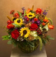 a vase filled with lots of colorful flowers