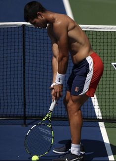 a man holding a tennis racquet on top of a tennis court next to a net