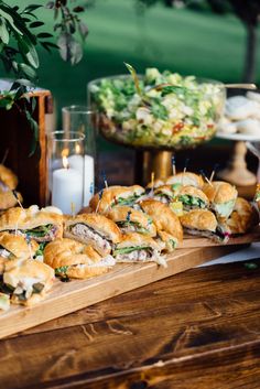 a wooden table topped with lots of sandwiches